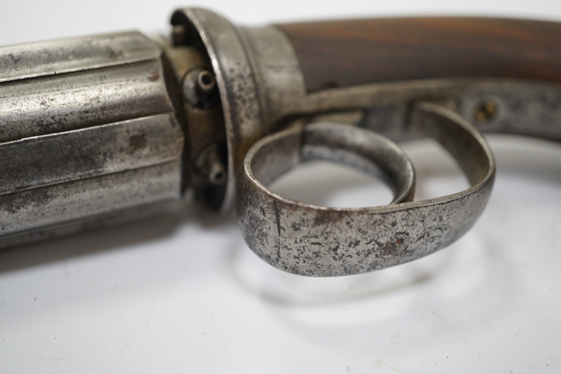 A six shot self-cocking percussion pepper box revolver, with fluted barrels, Birmingham proofed, round frame, and scroll engraved wooden grips, barrel 6.5cm. Condition - fair, alterations to the frame and grip.